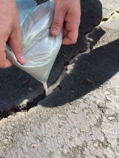 a person is holding something in their hand on the street with it's cement