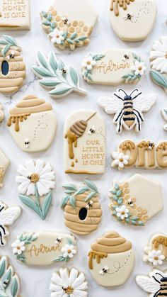 decorated cookies are arranged on a table with flowers and honeycombs in the shape of bees