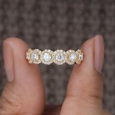 a close up of a person holding a ring with diamonds on it's sides