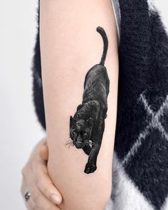 a black cat tattoo on the right arm