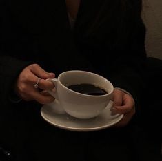 a woman holding a cup of coffee in her hands