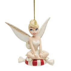 a christmas ornament with a fairy sitting on top of a red and white striped ball