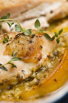 a close up of food on a plate with bread and herbs in the background,