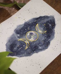 a painting with the moon and stars on it is sitting on top of a table