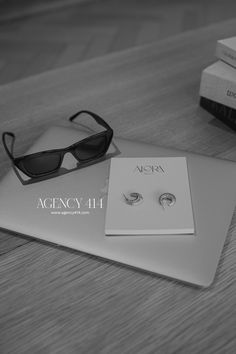 a pair of black and white sunglasses sitting on top of a table next to some books