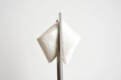 a piece of cloth is on top of a metal pole in front of a white wall