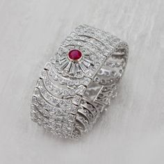 A breathtaking Art Deco style bracelet featuring a Burmese Ruby center stone. Masterfully hand-crafted in 18k White Gold. Feauting 13.21cts of Si-i1 Diamonds. Gemstone Details: Featuring a magnificent Burmese Ruby 2.24ct hearted round Carat Weight: 2.24 carat This stunning Ruby Diamond Bracelet is only available at Burdeen's Jewelry. Great gift idea for wedding or anniversary! We have many unique offerings of period fine jewelry posted on our Etsy store. Consider browsing all styles. Call us tod Luxury Brilliant Cut Cuff Bracelet For Wedding, Luxury Wedding Cuff Bracelet With Brilliant Cut, Formal Fine Jewelry Cuff Bracelet With Gemstone, Fine Jewelry Gemstone Cuff Bracelet For Formal Occasions, Luxury Gemstone Cuff Bracelet For Anniversary, Formal Gemstone Cuff Bracelet, Luxury Gemstone Cuff Bracelet For Weddings, Diamond Bangle Fine Jewelry Hallmarked, Hallmarked Diamond Bangle Fine Jewelry