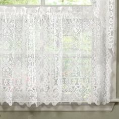 a white lace curtain hanging on a window sill