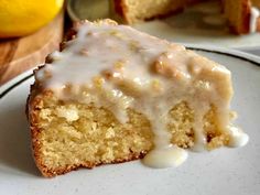 a close up of a piece of cake on a plate with lemons in the background