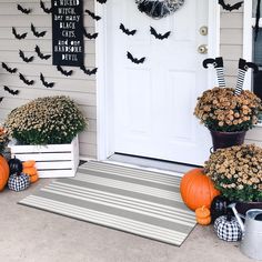 the front porch is decorated for halloween with pumpkins and flowers