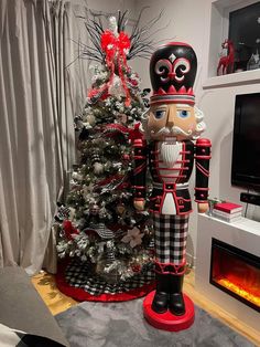 an inflatable nutcracker stands next to a decorated christmas tree and fireplace