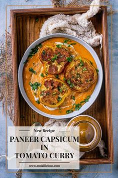 paneer capricum in tomato curry recipe on a wooden tray with spoons