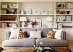 a living room filled with furniture and lots of shelves