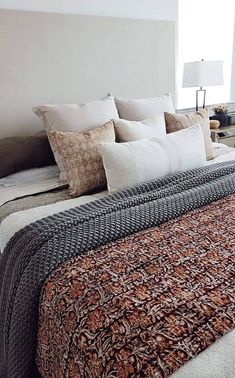 a bed with many pillows on top of it