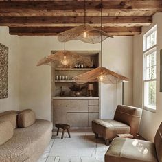 a living room filled with furniture and lots of lights hanging from the ceiling above it