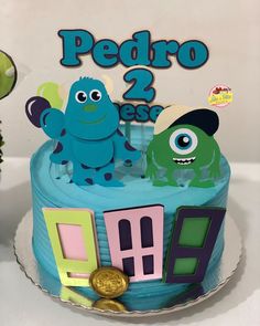 a blue cake with two monsters on top and the words pedro 2 is spelled out