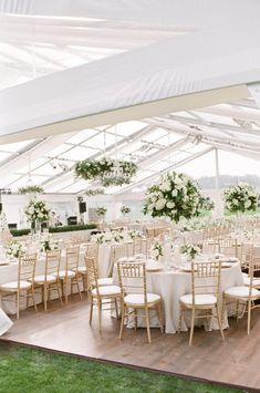 an outdoor tent with tables and chairs set up for a wedding