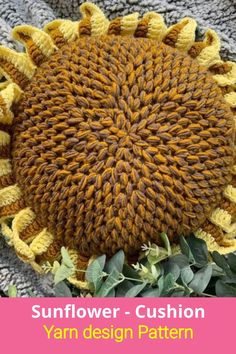 a yellow knitted sunflower laying on top of a blanket