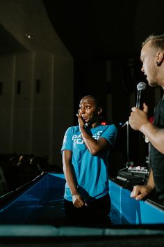 two men standing in front of a microphone