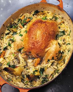 a close up of a chicken in a pot filled with pasta and veggies