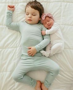 two babies are sleeping on top of each other