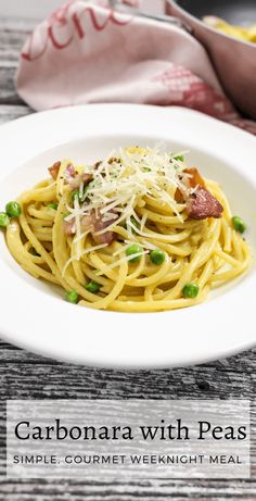 a white plate topped with pasta covered in bacon and peas on top of a wooden table