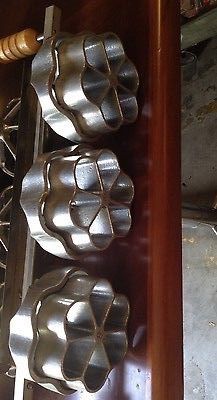 metal utensils sitting on top of a wooden shelf next to a knife and fork