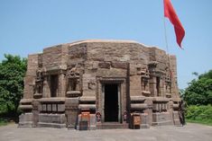 an old stone building with a red flag on top