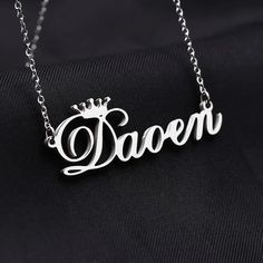 Personalized Crown Name Necklace is a personalized custom cursive font single name necklace gifted with the spirits of absolute glimmer. This beautiful piece of necklace with the queen's crown is an identical design that delivers the royal impression. The nameplate of the necklace can carry up to 10 letters of your choice for all the four types of custom chain lengths. Here we apply a crown symbol on top of the first letter of the name. Consider it as an added bonus to boost the prestigiousness Silver Nameplate Necklaces With Custom Text, Custom Name Necklace In White Gold For Birthday, Custom Text Silver Nameplate Necklaces, Silver Nameplate Necklace With Custom Text, Elegant Custom Text Name Necklace For Birthday, Custom Silver Wedding Necklace With Names, Silver Necklaces With Custom Text For Birthday, Silver Jewelry With Custom Text For Birthday Gift, Silver Personalized Necklace For Birthday