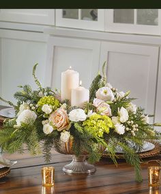 a centerpiece with candles and flowers on a table