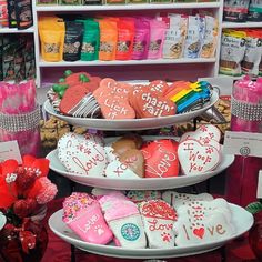 three tiered trays filled with heart shaped cookies on top of a table in a store