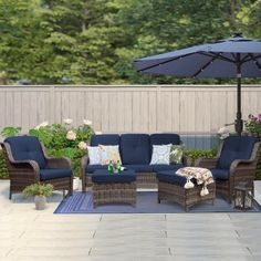 an outdoor patio with blue furniture and umbrella