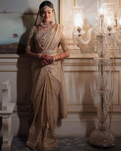 a woman standing in front of a chandelier