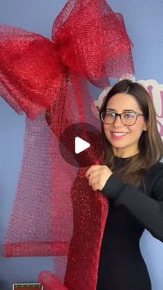 a woman is holding up a red bow