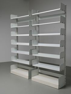 two metal shelvings are stacked on top of each other in an empty room