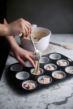 a person is making cupcakes in a muffin tin