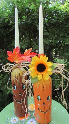 two decorated vases with candles sitting on a table