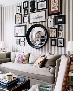 a living room filled with furniture and framed pictures on the wall above it's coffee table