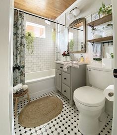 a white toilet sitting next to a bath tub in a bathroom under a wooden ceiling