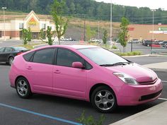 a pink car is parked in a parking lot