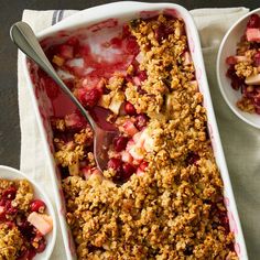 a dish with fruit and crumbled oatmeal in it next to two bowls