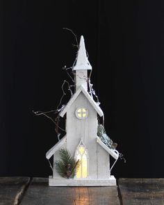 a small white church with christmas decorations on it