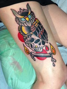 an owl tattoo on the leg of a woman's lower body, with a knife in it