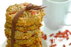 a stack of cookies sitting on top of a white plate next to a coffee cup