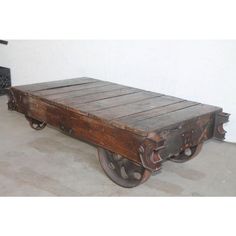 an old wooden cart with wheels on the floor