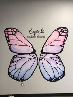 a large butterfly painted on the side of a wall with writing underneath it that reads, kemppiki academy of dance