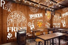 a pizza restaurant with wooden walls and tables in front of the wall is decorated with chalk writing