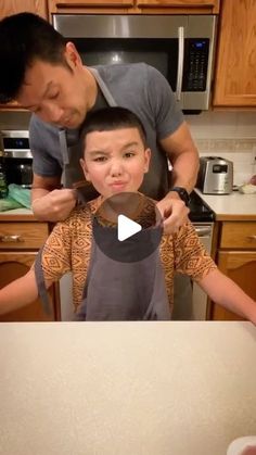 a man standing next to a little boy in a kitchen