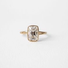 an engagement ring with a square cut diamond in the center, on a white background