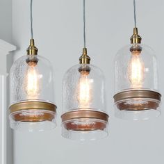 three clear glass lights hanging from a ceiling